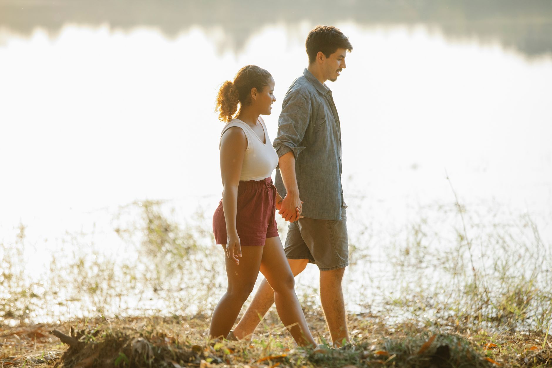Man en vrouw lopen hand in hand naast elkaar langs het water
